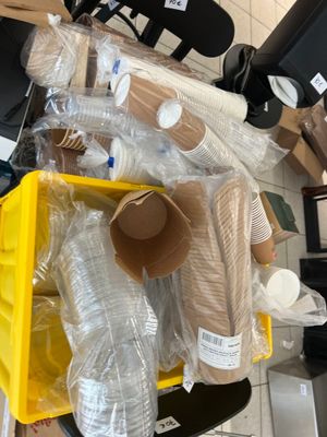 un bac jaune rempli de gobelets en plastique et d'autres objets