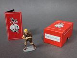 toy figurine of a man holding a baseball bat next to a red box
