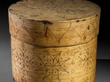 une vieille boîte en bois posée sur une table, devant un fond noir
