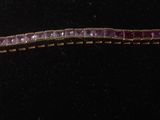 purple and gold bracelet on a black mannequin display