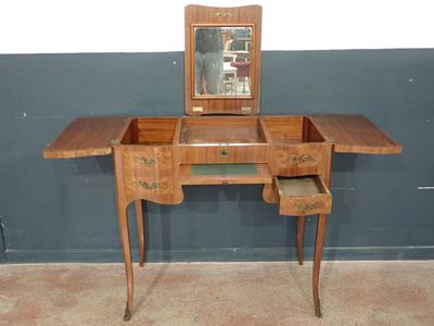 a small wooden desk with a mirror on top of it
