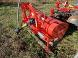 une machine rouge qui est garée dans l'herbe