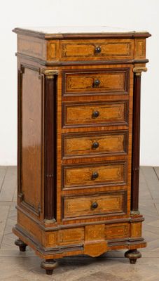 une commode ancienne en bois montée sur roulettes, posée sur un sol carrelé