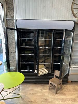 une image d'une cuisine avec un réfrigérateur et une table