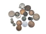 a close up of a pile of old coins on a white surface