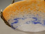 a bowl hanging from a gold chain on a wall