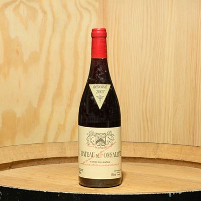 a bottle of wine sitting on top of a barrel