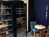 tables and chairs in a room with a glass door and blue curtains