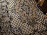 un salon avec un tapis et un fauteuil