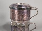 a silver plate and a silver cup on a table