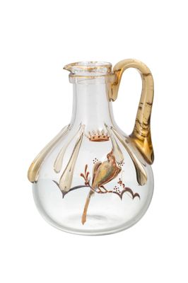 un vase en verre orné d'une poignée dorée et d'un oiseau