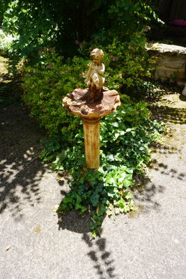 un bain d'oiseaux au milieu d'un jardin