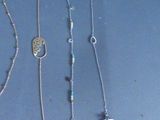 several different necklaces and bracelets are displayed on a table