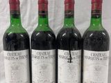 four bottles of wine are lined up on a white surface