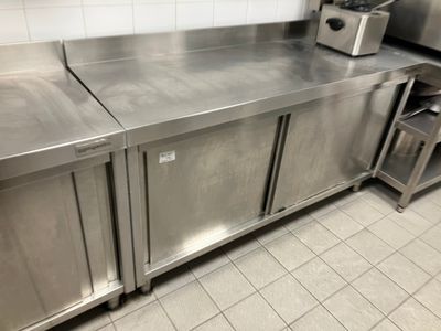 a stainless steel counter in a kitchen with a toaster on it