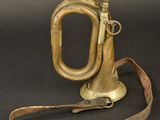 an old brass trumpet with a leather strap on a black background
