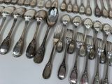 a lot of silver spoons and forks on the table