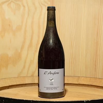 a bottle of wine sitting on top of a wooden barrel