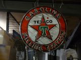 une enseigne « Texacoo » rouge et blanche suspendue au plafond