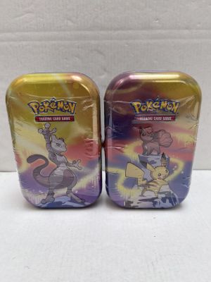 two tins of pokemon tins are sitting on a white surface