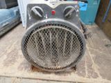 an old fan heater sitting on the floor in a garage