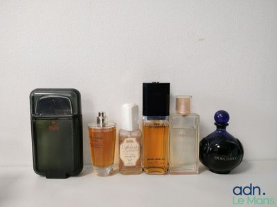 de nombreux flacons de parfum de toutes sortes alignés sur une étagère