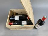 bottles of wine in a wooden box on a gray surface