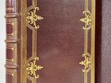 a close up of a brown book with a gold trim
