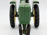 a green toy tractor that is sitting on a white surface