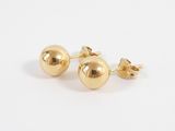 a pair of gold ball earrings on a white background