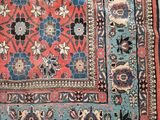 an antique persian rug with a floral design on a blue ground