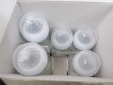 six empty bottles in a white box on a table