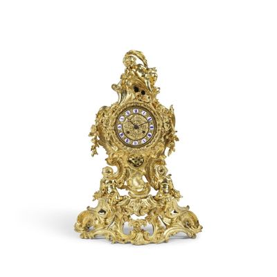 une horloge en or posée sur une surface blanche