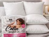 two pillows on a bed with a pillow on top of it