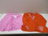 two shirts that are sitting on a white table