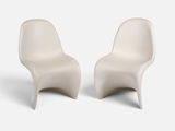 deux chaises blanches placées l'une à côté de l'autre sur une surface blanche