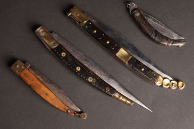 Plusieurs types de couteaux sont alignés sur une surface noire