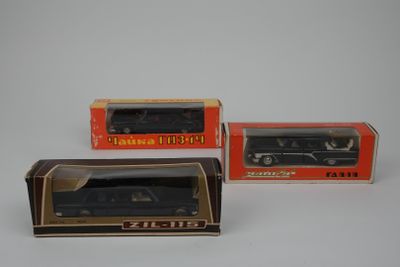 three boxed boxed toy cars in boxes on a white surface
