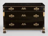une commode noire et dorée à quatre tiroirs