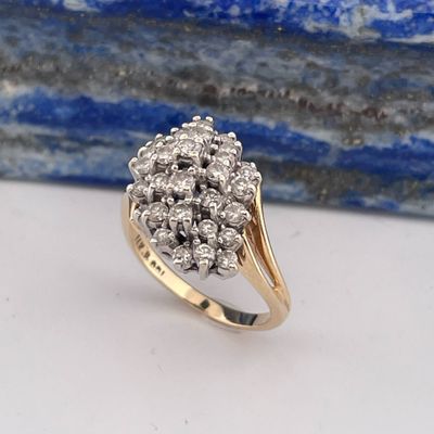 un gros plan d'une bague sertie de diamants en grappe posée sur une table