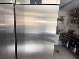 a stainless steel refrigerator in a kitchen with a tile floor