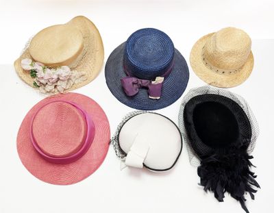plusieurs chapeaux sont alignés sur une surface blanche