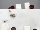 Plusieurs bagues de différents types sont posées sur un bloc de marbre blanc.