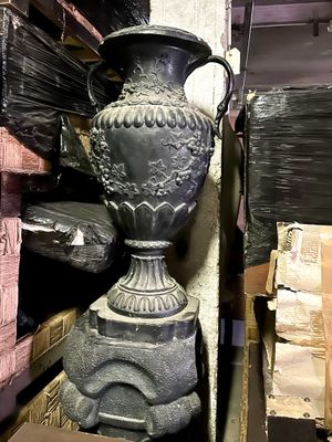 a black vase sitting on top of a stack of boxes