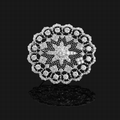 a diamond and white gold broochle, by van cleef