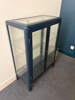 a glass display case with a black base and glass shelves