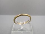 une photo d'une bague en or posée sur une boîte transparente