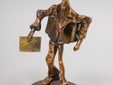 bronze figurine of a man holding a letter and a bag
