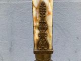 an image of a statue of a woman holding a cross on a pedestal