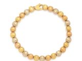 un bracelet orné de perles dorées sur fond blanc